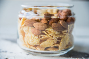 Homemade granola with nuts and seeds in glass jar for healthy breakfast