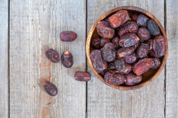 Fresh dates in wooden bowl. Love for a healthy vegan food concept.