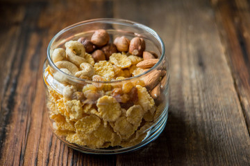 Homemade granola with nuts and seeds in glass jar for healthy breakfast