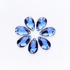 Precious stones light sapphire color in the shape a tear drop on a white background.