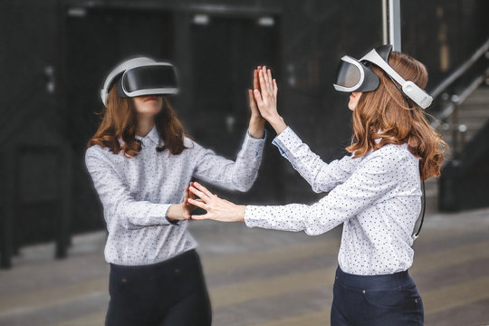 Woman with VR glasses of virtual reality. Young girl in virtual augmented reality helmet. VR headset. Future technology concept