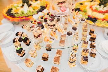 Delicious sweets on wedding candy buffet with desserts, cupcakes