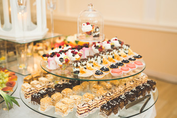 Delicious sweets on wedding candy buffet with desserts, cupcakes