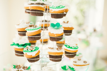 Delicious and tasty dessert table with cupcakes shots at reception closeup
