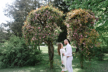 Young, beautiful bride and groom walking along the street in the city