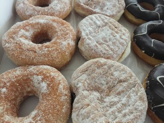Doughnut with powder sugar topping,stacked in row,abstract art design,blurry light background