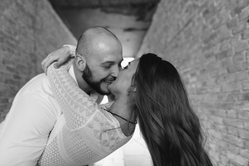 Young, beautiful bride and groom walking along the street in the city