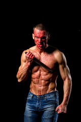 scary fitness muscular male model covered in blood with knife