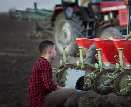 Farmer with laptop and tractors