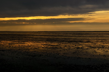 Fototapeta premium Reflections of sunset in low tide beach