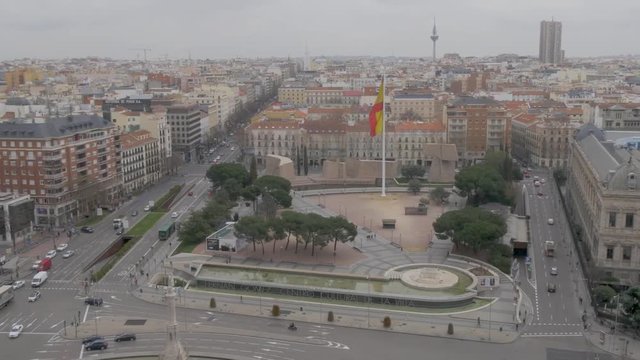 Panoramic of the square colon of madrid paseo de la castellana with flag of spain giant waving from height 