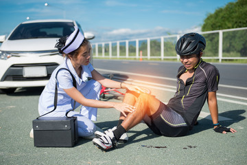 Female nurse helping emergency asia cyclist injured on the street bike after collision accident car and bike