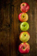 Fresh red apples with green leaves on wooden table. On wooden background. Free space for text . Top view