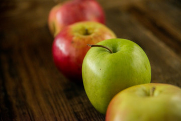 Fresh red apples with green leaves on wooden table. On wooden background. Free space for text . Top view