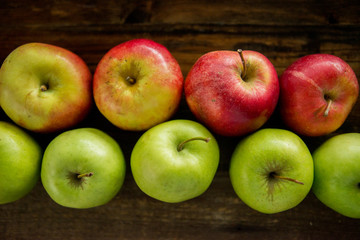 Fresh red apples with green leaves on wooden table. On wooden background. Free space for text . Top view