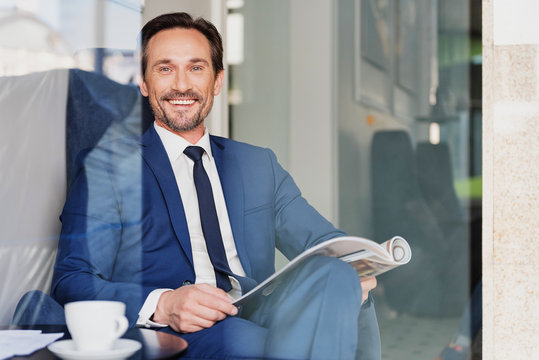 Happy male manager relaxing in cafeteria
