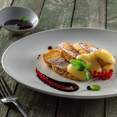 Delicious toasts with fruit jam and custard on a plate. Healthy European breakfast on a rustic wooden table. Close-up shot.
