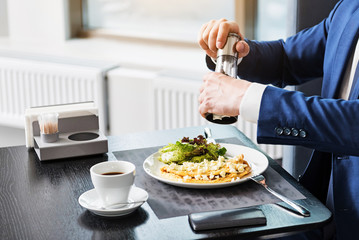 Elegant businessman adding pepper in dish