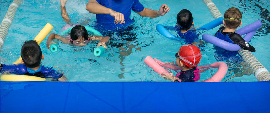 Kids learn how to swim in swimming class