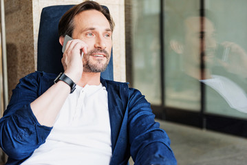 Positive businessman communicating on cellphone