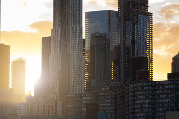 Sunset light shines through New York City skyline of modern style buildings