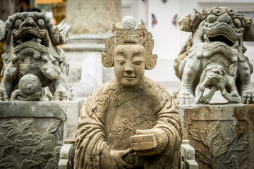 old statue in public temple in Thailand with dramatic tone