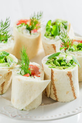 Tasty tortilla with salmon, cheese and vegetables on white table