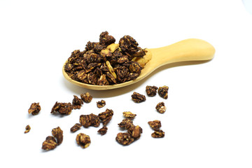 Chocolate Granola in the wooden spoon on white background.