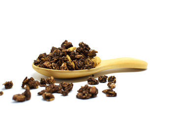 Chocolate Granola in the wooden spoon on white background.