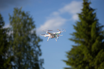 Drone with the camera against the blue sky.