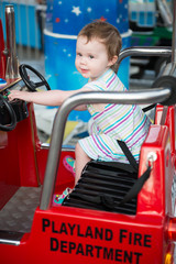 Young toddler girl riding on boardwalk amusement ride