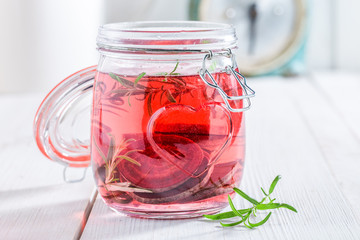 Closeup of water in jar with beetroot and rosemary