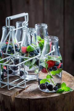 Closeup of water in bottle with raspberries, blueberries and blackberries