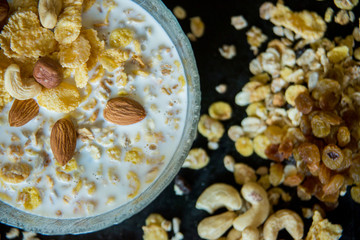 Healthy breakfast. Fresh granola, muesli with berries, honey in a glass jar on a black slate background.