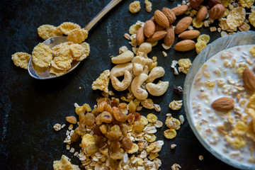 Healthy breakfast. Fresh granola, muesli with berries, honey in a glass jar on a black slate background.