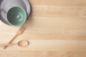 plate and cup with spoon and fork on wood table with copy space