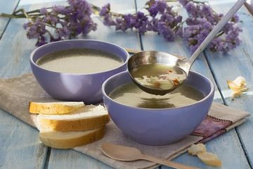 Homemade  soup on chicken broth with pasta and vegetables on a blue wooden table.