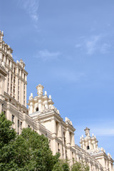 Obraz premium A beautiful tall building, a Stalin skyscraper on the background of a part of the building of the ukraine hotel against the blue sky