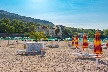 Fototapeta na wymiar Black sea, sand beach with umbrellas and white sun chairs, Balchik, Bulgaria