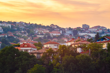 Fototapeta premium Golden sunset scenery view on houses on the hill in Balchik city, Bulgaria