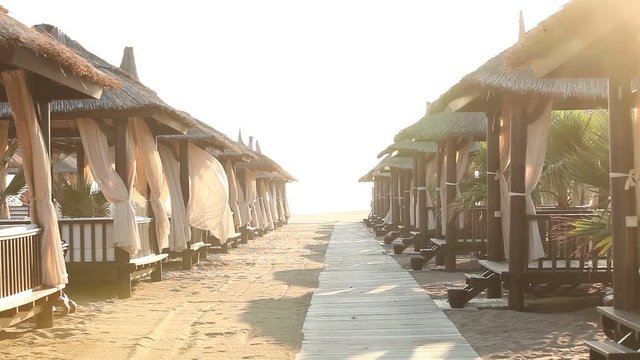 Sandy Beach With Thatched Umbrellas On A Windy Day, Beach umbrellas by the ocean