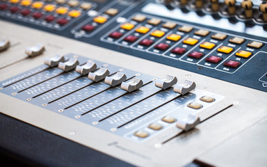 Close view of mixing console faders