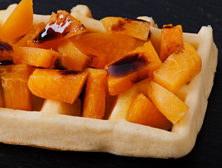 Belgian waffles with pieces of apricot and chocolate sauce.