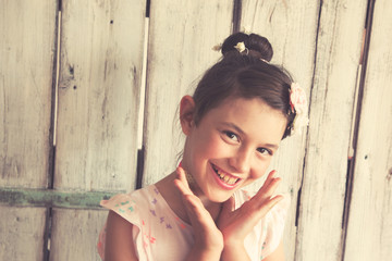 Delighted little girl posing / Cheerful little girl with flowers in her hair posing in front of white background