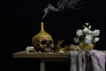 Pile of Skulls and bones on the reflection floor and old dirty wall have Lighting by candlelight /...