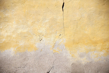 Riss in vergilbter Fassade  / Die Nahaufnahme einer vergilbten Fassade mit einem Riss in der Wand.