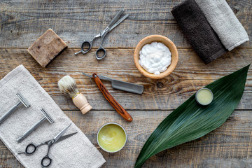 Fototapeta na wymiar Barber workplace. Shaving brush, razor, foam, sciccors on wooden table background top view