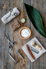 Barber workplace. Shaving brush, razor, foam, sciccors on wooden table background top view