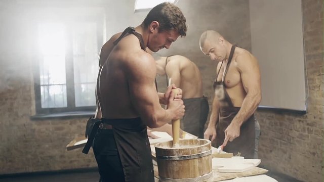 Handsome topless craftsmen working plaster