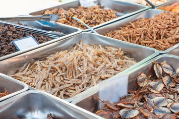 Various crispy fish and squid in aluminium tray at Thailand food street market.